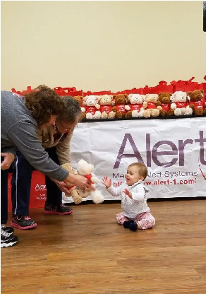 Seniors giving baby a bear Seniors giving baby a bear